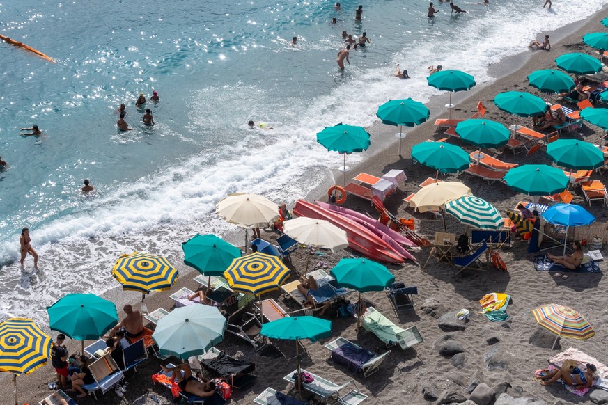 Amalfi Coast, Italy - 22 July 2023: Parasols and many vacationers on the Amalfi Coast in Italy. Beach and vacation by the sea *** Sonnenschirme und viele Urlauber an der Amalfik