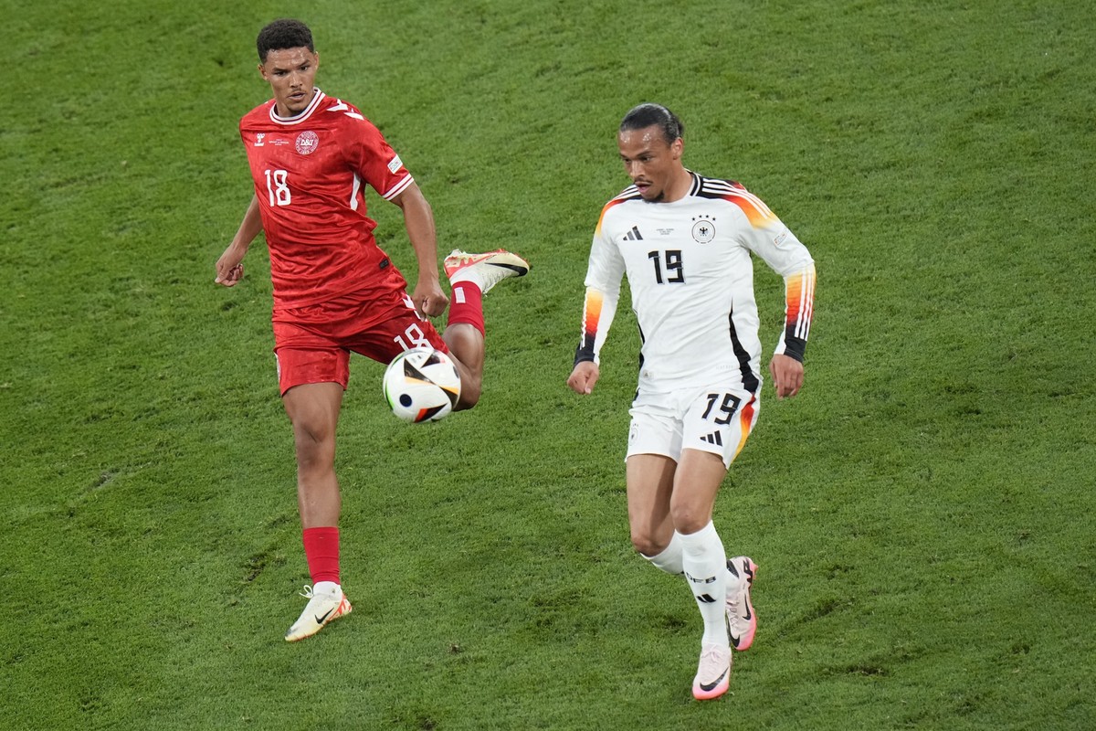 Denmark&#039;s Alexander Bah, left, challenges for the ball with Germany&#039;s Leroy Sane during a round of sixteen match between Germany and Denmark at the Euro 2024 soccer tournament in Dortmund, G ...