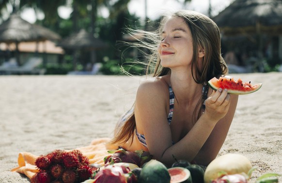 Caucasian woman eating watermelon on beach, Kaukasische Frau Wassermelone am Strand zu essen || Modellfreigabe vorhanden