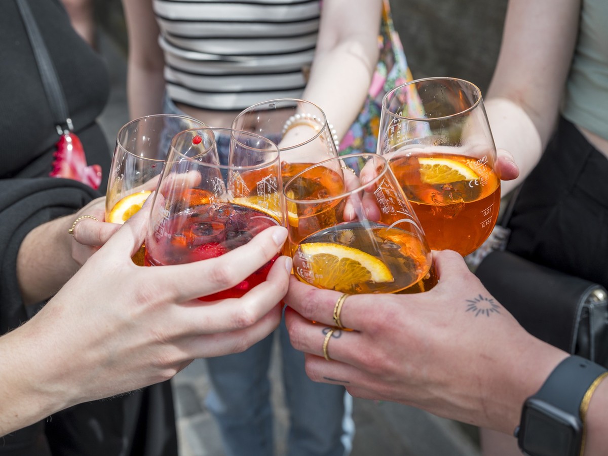 01.05.2024, Bayern, Bamberg: Fünf Personen stoßen mit ihren Gläsern mit Aperol Spritz an. Foto: Daniel Vogl/dpa +++ dpa-Bildfunk +++