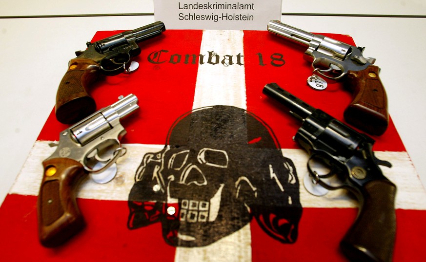 FILE PHOTO: Confiscated guns and Neo Nazi propaganda material is displayed during a news conference at a police station in the northern German Baltic Sea coastal town of Kiel October 28, 2003. German  ...