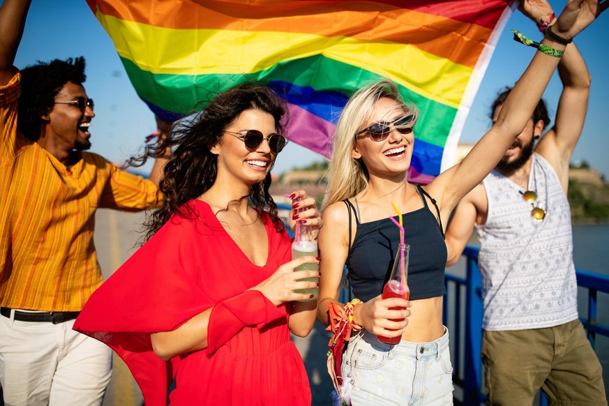 Freunde feiern mit Regenbogen-Flagge