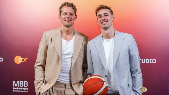 ARCHIV - 23.09.2024, Berlin: Basketball: Die Basketballprofis und Brüder Moritz Wagner (l) und Franz Wagner stehen mit einem Basketball bei einem Fototermin vor der Preview zum Teil 1 der ZDF-Doku &qu ...