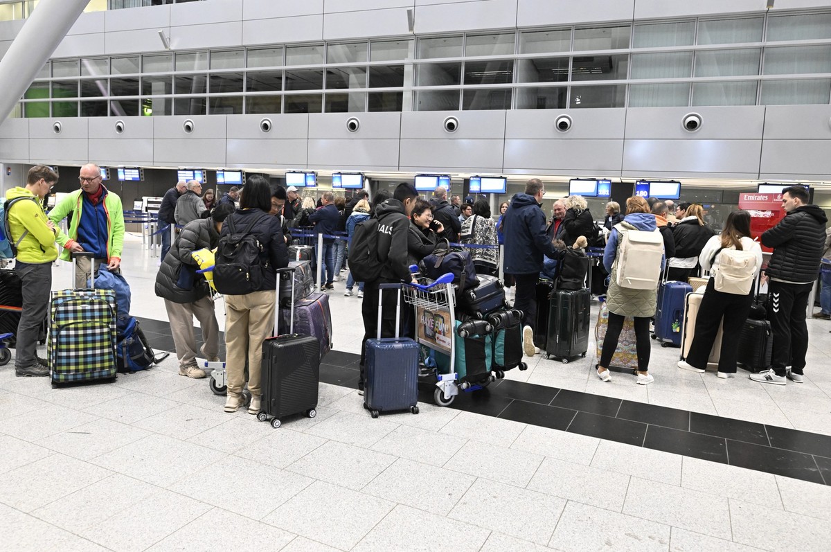 03.01.2025, Nordrhein-Westfalen, Düsseldorf: Reisende bilden am Flughafen beim Check-In eine Schlange. Auf Grund von IT- Störungen bei der Bundespolizei ist es bundesweit zu Verzögerungen bei der Ein- ...
