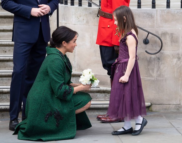 Commonwealth Day 2019 The Duchess of Sussex wearing a green Erdem coat and dress, bends to chat to a child as she attends a Commonwealth Day youth event at Canada House in London on March 11, 2019. PU ...