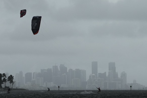 27.09.2022, USA, Coral Gables: Vor der Skyline von Miami nutzen Kite-Surfer im Matheson Hammock Park die starken Winde, die der entfernte Hurrikan �Ian� verursacht. Foto: Rebecca Blackwell/AP/dpa +++  ...