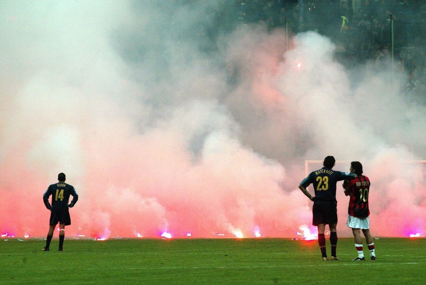 2005: Im Mailänder Derby zwischen AC und Inter artete das Zünden von Pyros damals derart aus, dass es zum Spielabbruch kam. Juan Veron, Marco Materazzi und Rui Costa schauen den Flammen zu.