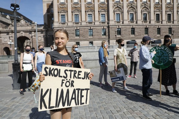 dpatopbilder - 02.07.2021, Schweden, Stockholm: Greta Thunberg, Klimaaktivistin aus Schweden, h�lt ein Schild mit der Aufschrift �Skolstrejk F�r Klimatet� (�Schulstreik f�r das Klima�), und nimmt geme ...