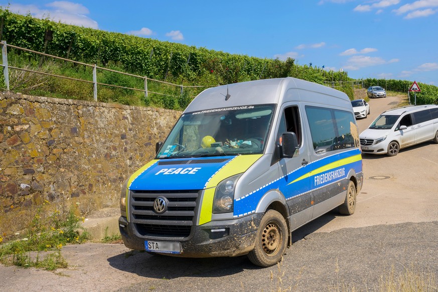 Mit der Aufschrift "Friedensfahrzeug" fährt dieser Transporter am Rand des Katastrophengebiets in den Weinbergen entlang.