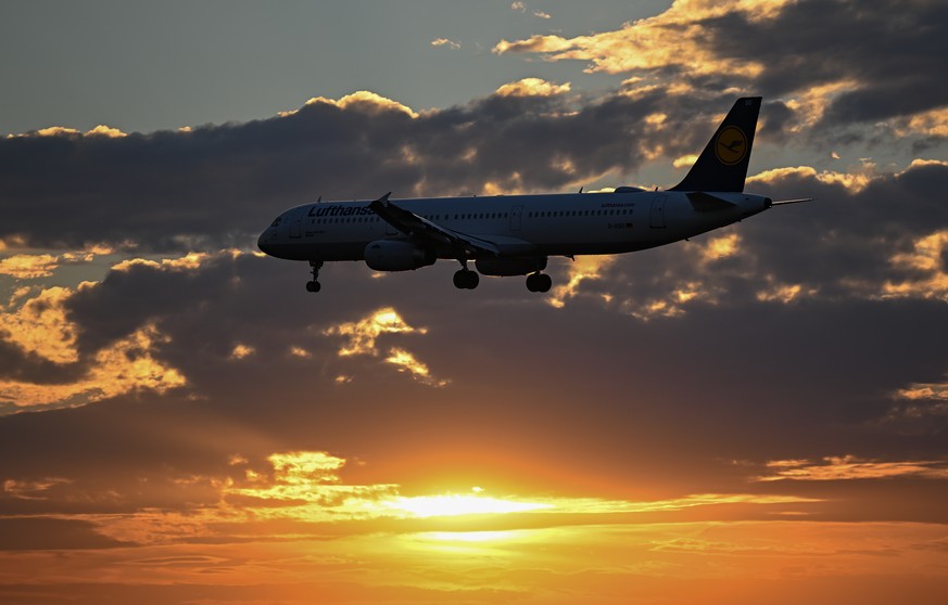 13.07.2022, Hessen, Frankfurt/Main: Eine Maschine der Lufthansa landet bei Sonnenuntergang am Frankfurter Flughafen. Angesichts ungebrochener Reiselust und massiver Probleme bei der Abfertigung m