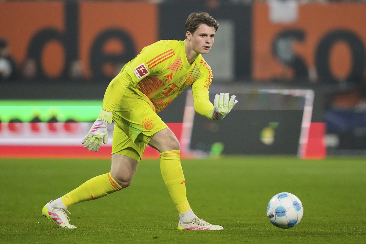 Bayern&#039;s Jonas Urbig passes the ball during the German Bundesliga soccer match between Augsburg and Bayern Munich in Augsburg, Friday, April 4, 2025. (AP Photo/Matthias Schrader)