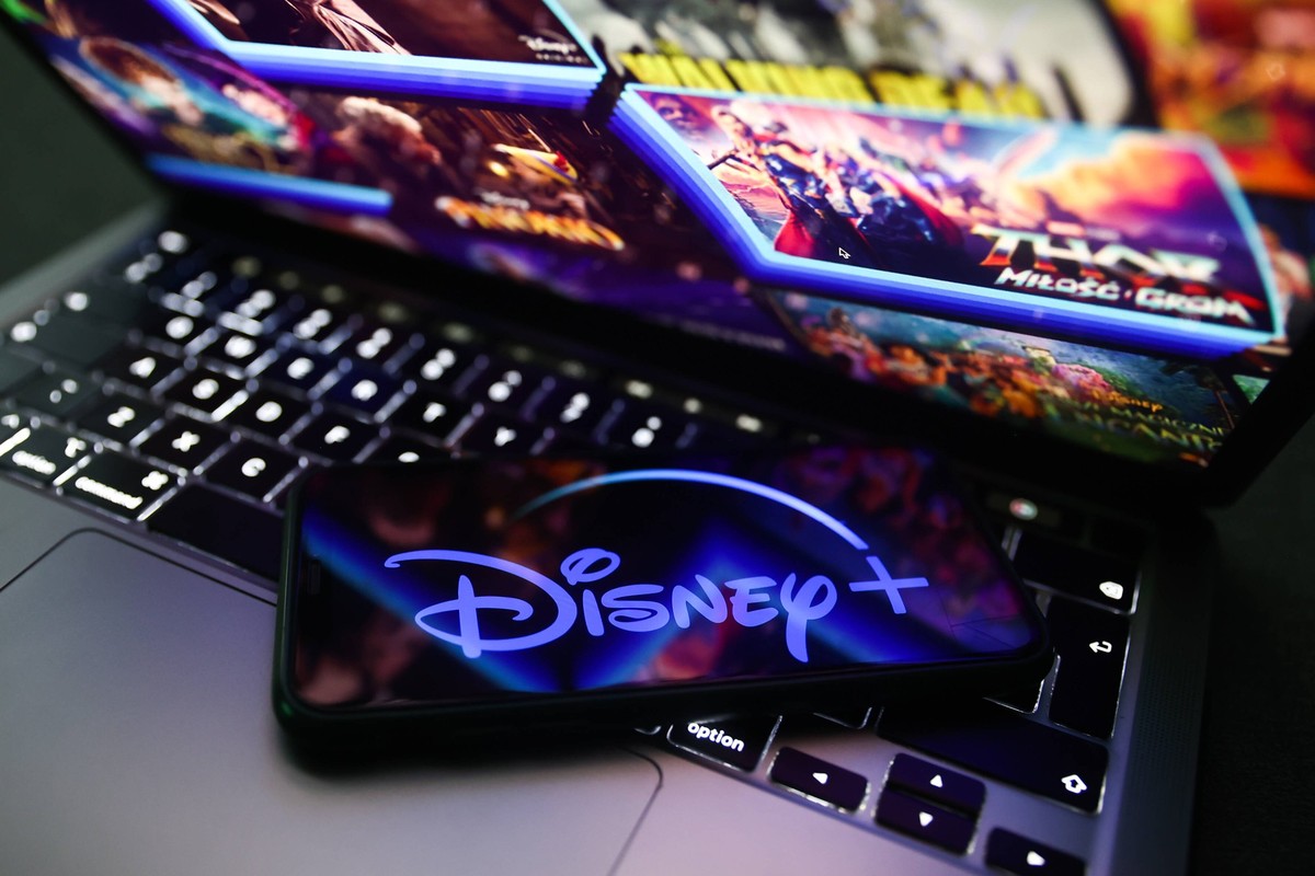 Popular Streaming Services Photo Illustrations Disney logo displayed on a phone screen and Disney website displayed on a laptop screen are seen in this illustration photo taken in Krakow, Poland on No ...