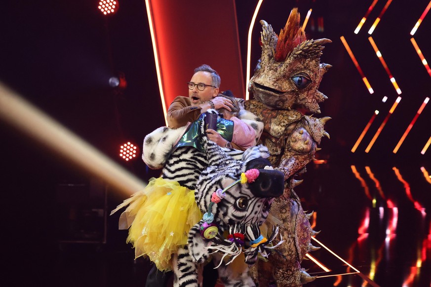 COLOGNE, GERMANY - APRIL 23: &quot;Das Zebra&quot; loses their mask after being announced winner as they are hugging Host Matthias Opdenhoevel during the finals of the 6th season of &quot;The Masked S ...