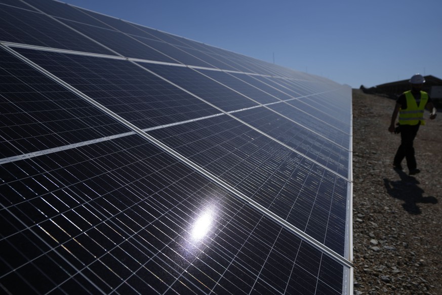 A maintenance engineer walks at a new solar park outside the northern Greek city of Kozani on Friday, June 3, 2022. The newly-completed solar park, one of Europe's largest, is just a half-hour drive f ...
