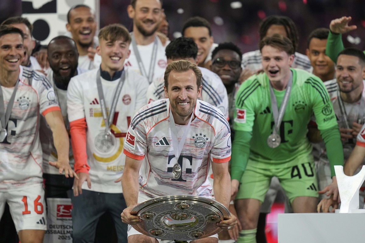 Bayern&#039;s Harry Kane celebrates with the championship shield after the German Bundesliga soccer match between FC Bayern Munich and Borussia Moenchengladbach in Munich, Germany, Saturday, May 10, 2 ...