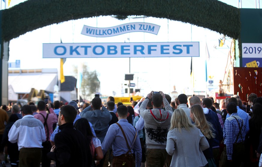 FILE PHOTO: People run to get a spot at the Oktoberfest area at the opening day of the 186th Oktoberfest in Munich, Germany September 21, 2019. REUTERS/Michael Dalder - RC170CF207A0/File Photo