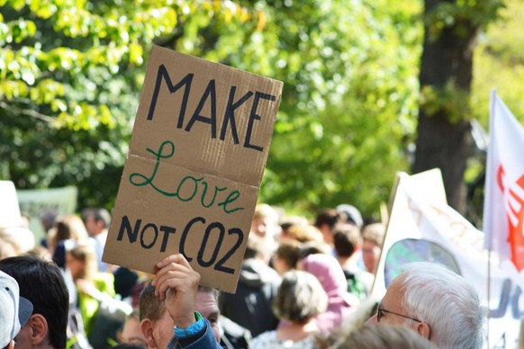 Protestschild mit der Aufschrift Make love, not CO2, das von jungen Menschen während des Freitagsstreiks für den zukünftigen Klimastreik hochgehalten wird, Heidelberg, Deutschland, Europa *** Protest  ...