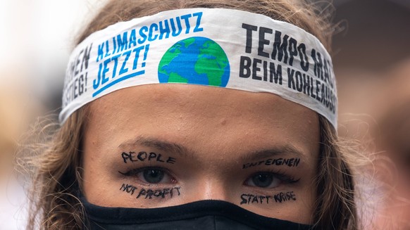 Fridays For Future Climate Demo In Cologne a protester with message of people not profit, expropriate instead crisis written on the face during climate protest in Cologne, Germany on August 27, 2022,  ...