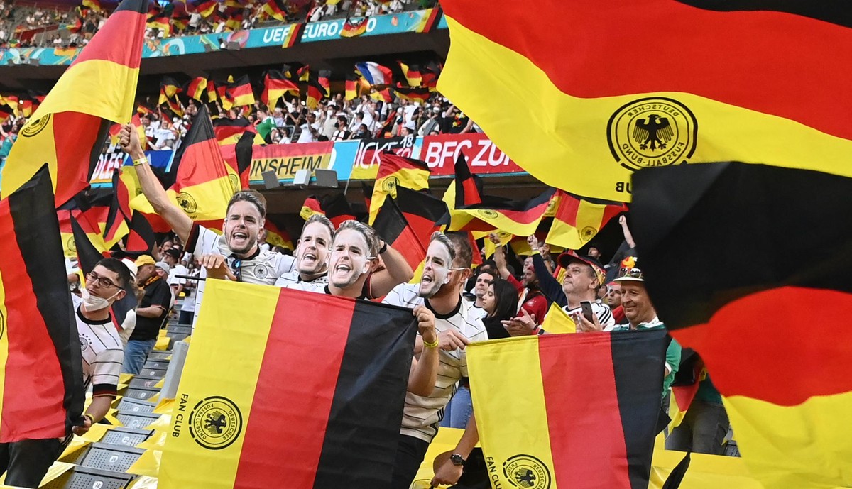 Fußball: EM, Frankreich - Deutschland, Vorrunde, Gruppe F, 1. Spieltag in der EM-Arena München. Fans feiern auf der Tribüne mit deutschen Fahnen vor dem Spiel. Important: For editorial news reporting ...