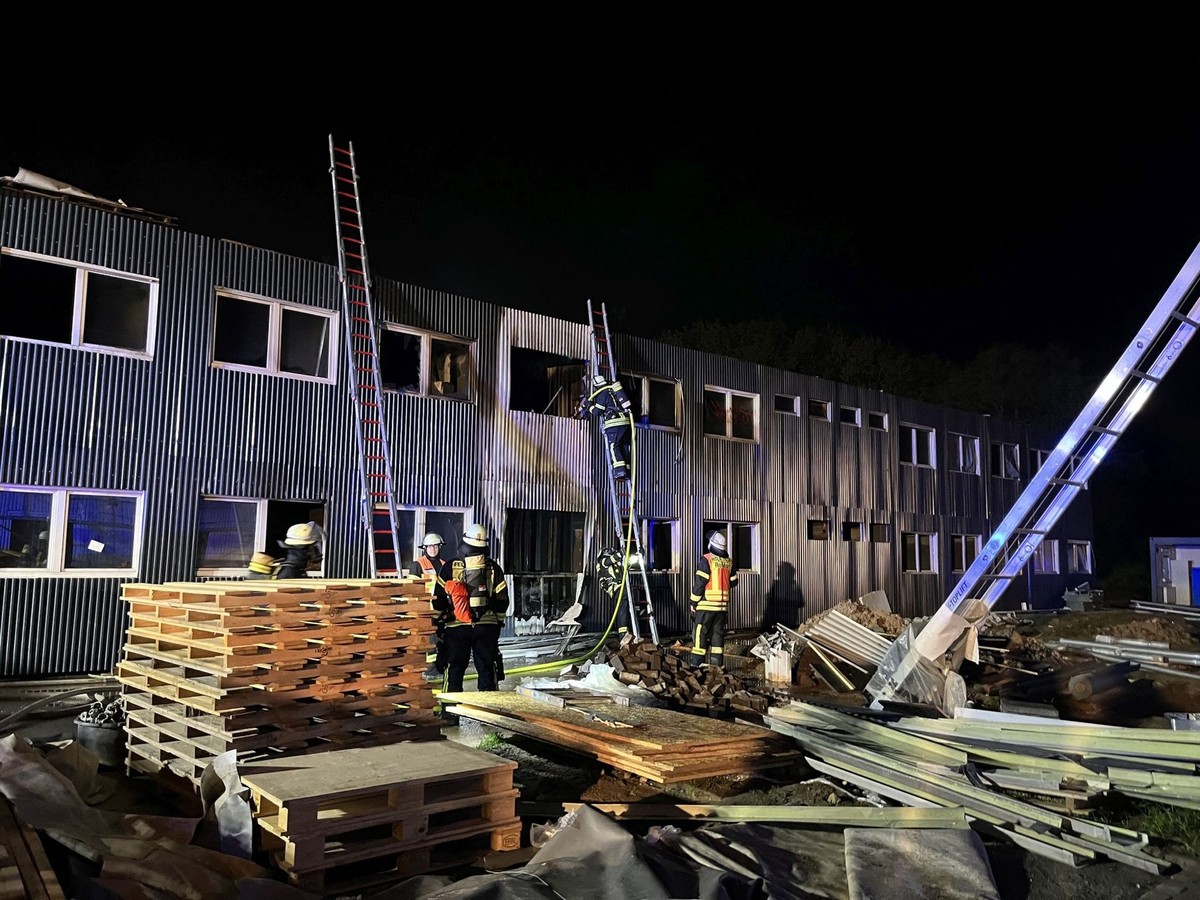 30.04.2023, Hessen, Roßdorf: Feuerwehrleute löschen einen Brand in einer noch unbewohnten und für die Unterbringung von Flüchtlingen vorgesehenen Containeranlage. (zu dpa: «Brand in Containeranlage fü ...