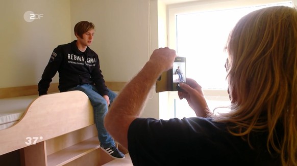 Dennis und sein Vater besichtigen sein Zimmer im Studentenwohnheim.