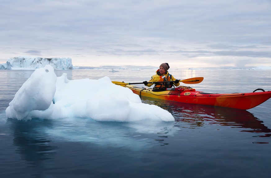 ILULISSAT, GREENLAND - SEPTEMBER 04: Guide Vilhelmine Nathanielsen observes ice while leading a kayak tour to icebergs which calved from the Sermeq Kujalleq glacier on September 4, 2021 in Ilulissat,  ...