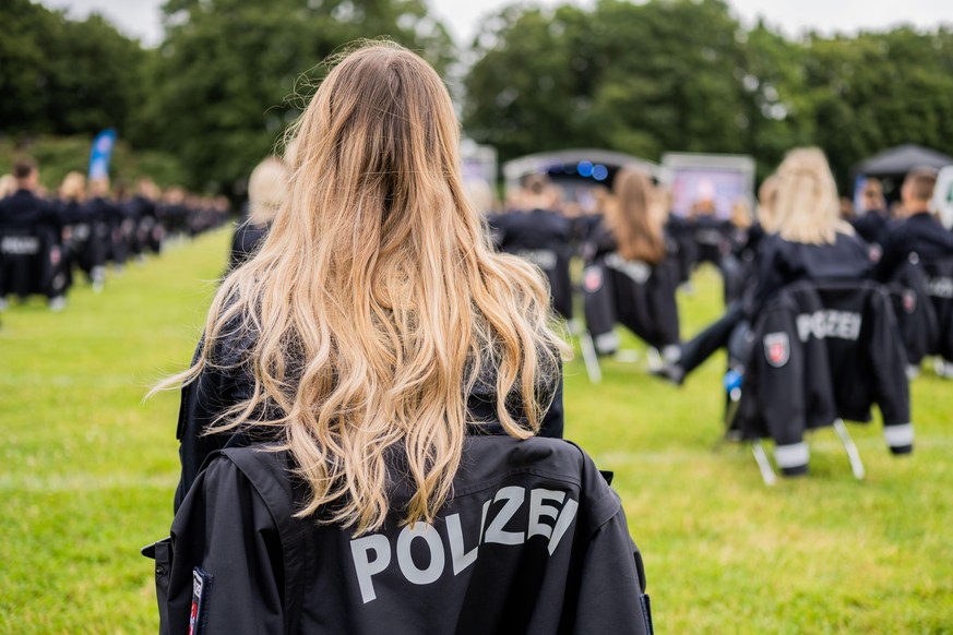 Eine Polizistin des 9. Bachelorstudienjahrgangs der Polizeiakademie Niedersachsen sitzt während ihrer Vereidigungsfeier auf einem Stuhl.