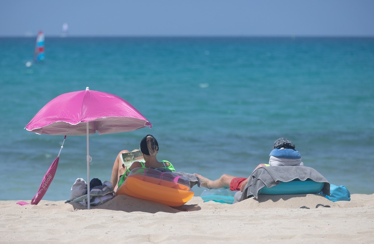 ARCHIV - 07.06.2025, Spanien, Palma: Menschen sonnen sich am Strand von Arenal auf Mallorca. (zu dpa: «Für Urlaub wird am häufigsten gespart») Foto: Clara Margais/dpa +++ dpa-Bildfunk +++