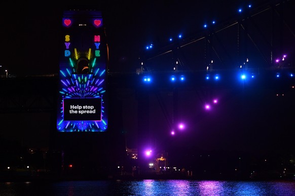 The Sydney Harbour Bridge pylon is lit with a COVID safe message ahead of the midnight fireworks during New Year’s Eve celebrations in Sydney, Thursday, December 31, 2020. Sydneysiders were asked to s ...