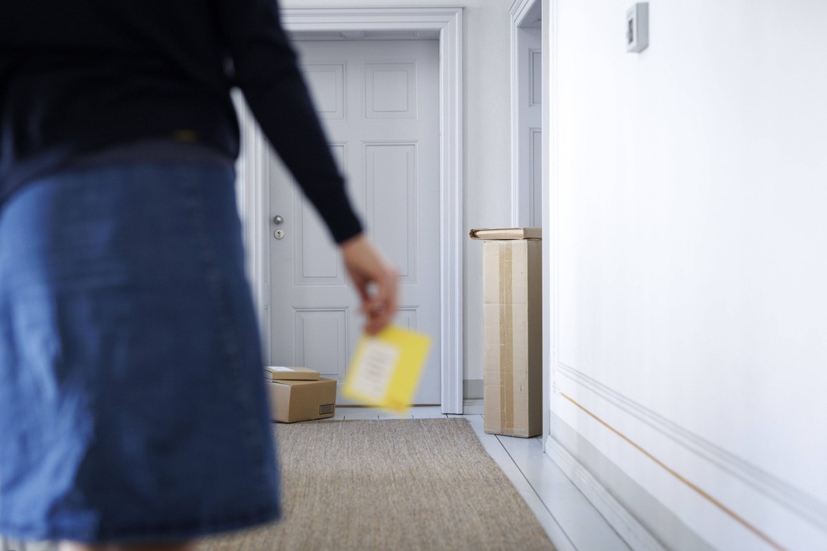 Eine Frau laeuft mit einem Paket-Abholschein durch ein Treppenhaus in Berlin, 08.08.2024. Berlin Deutschland *** A woman walks through a stairwell in Berlin with a parcel collection slip, 08 08 2024 B ...