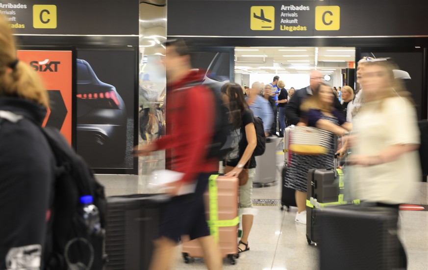 01.07.2023, Spanien, Palma: Passagiere kommen auf dem Flughafen von Palma de Mallorca an. Auf der beliebten Urlaubsinsel ist die Hauptreisesaison in vollem Gange. Foto: Clara Margais/dpa +++ dpa-Bildf ...