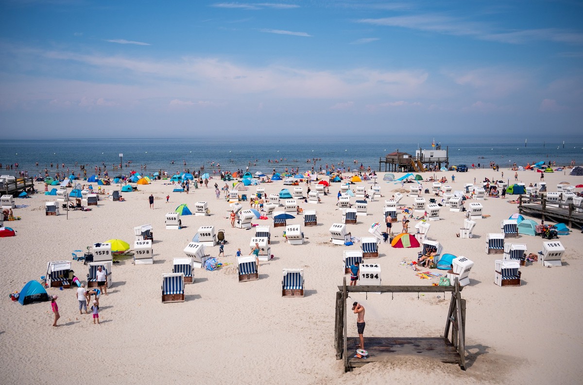 ARCHIV - 21.07.2024, Schleswig-Holstein, Sankt Peter-Ording: Zahlreiche Touristen sind bei Sonnenschein am Strand an der Nordsee unterwegs. (zu dpa: