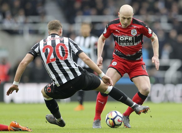 Newcastle United&#039;s Florian Lejeune, left, and Huddersfield Town&#039;s Aaron Mooy battle for the ball during their English Premier League soccer match at St James&#039; Park, Newcastle, England,  ...