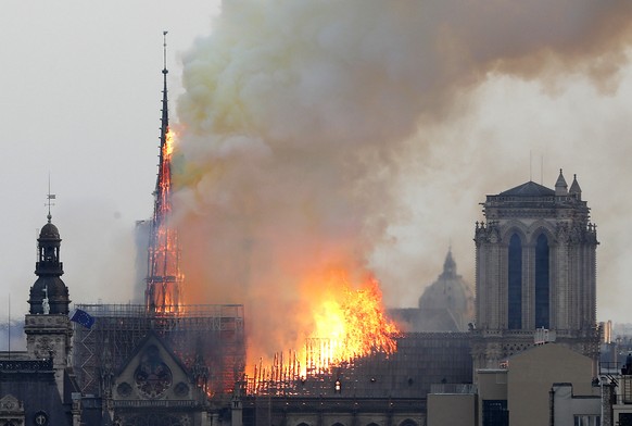 Flames rise from Notre Dame cathedral as it burns in Paris, Monday, April 15, 2019. Massive plumes of yellow brown smoke is filling the air above Notre Dame Cathedral and ash is falling on tourists an ...
