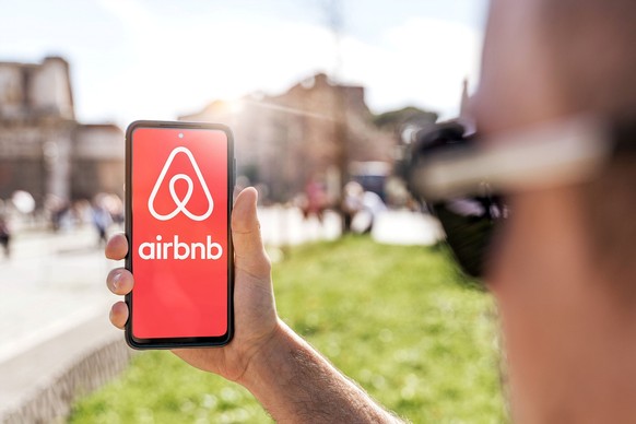 Mann bucht Airbnb via Smartphone