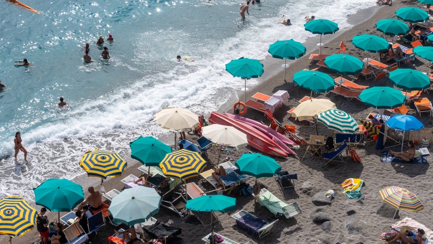 Amalfi Coast, Italy - 22 July 2023: Parasols and many vacationers on the Amalfi Coast in Italy. Beach and vacation by the sea *** Sonnenschirme und viele Urlauber an der Amalfik