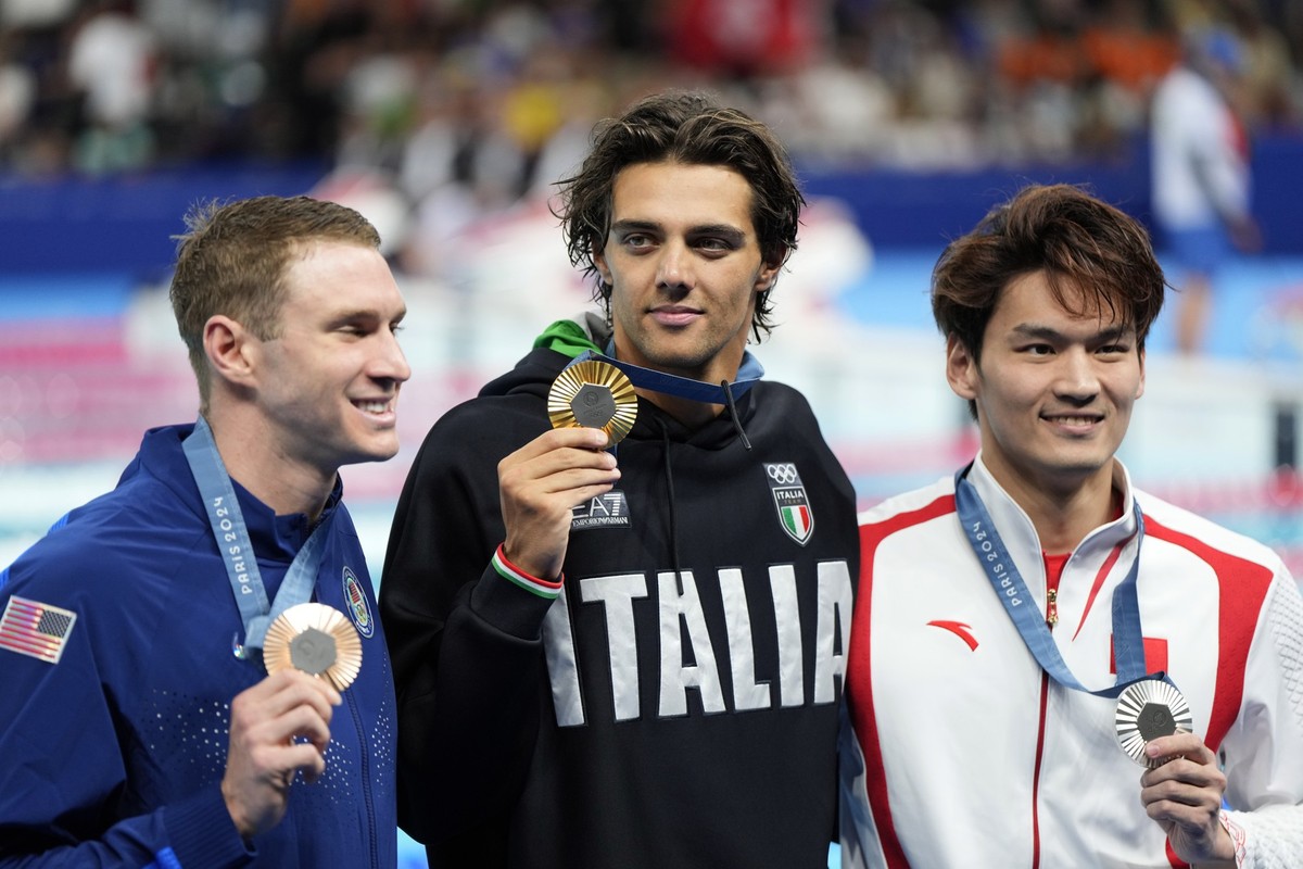 Gold medalist Thomas Ceccon, of Italy, poses with silver medalist Xu Jiayu, of China, left, and bronze medalist Ryan Murphy, of the United States, after the men&#039;s 100-meter backstroke final at th ...