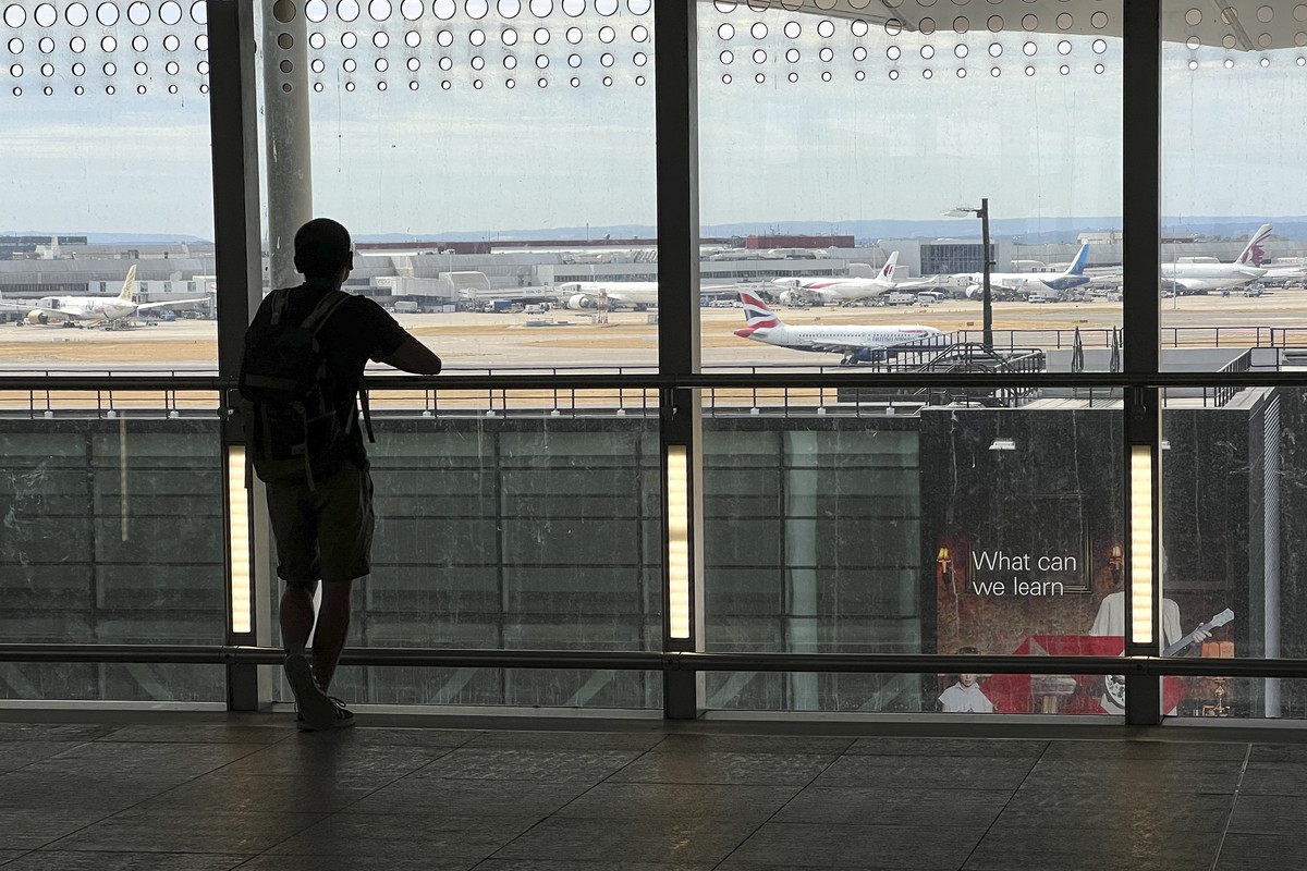13.07.2022, Gro�britannien, London: Ein Mann wartet am Flughafen Heathrow. Der Londoner Flughafen Heathrow hat ein Limit f�r die Zahl abreisender Passagiere f�r die Sommermonate eingef�hrt. Wie Gesch� ...