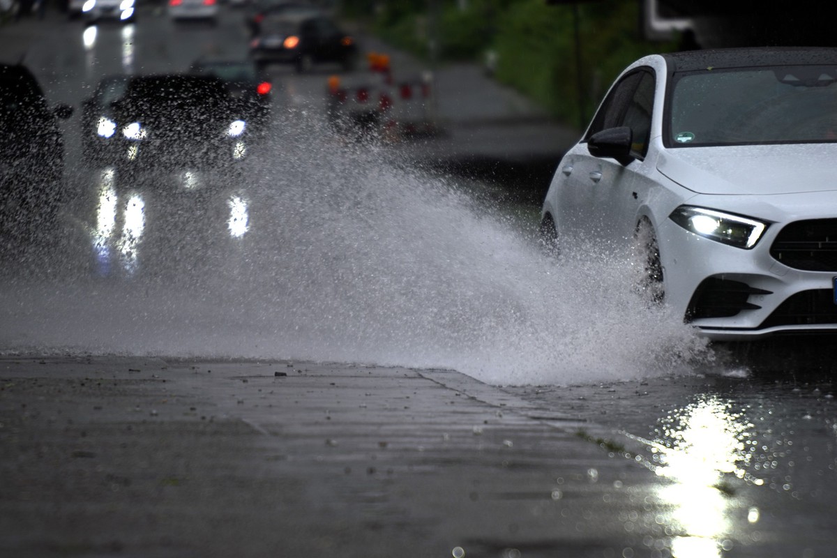 ARCHIV - 02.05.2024, Nordrhein-Westfalen, Köln: Ein Auto fährt durch eine große Wasserlache. (zu dpa: «Freitag in NRW erneut unwetterartiger Regen möglich») Foto: Federico Gambarini/dpa +++ dpa-Bildfu ...