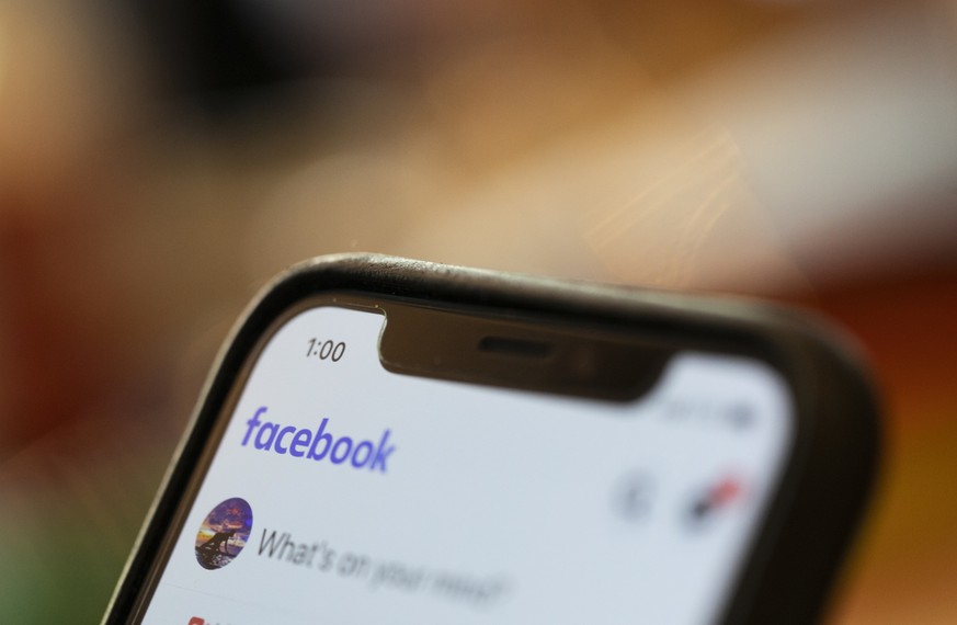 In this Sunday, Aug. 11, 2019, photo an iPhone displays a Facebook page in New Orleans. Facebook says it paid contractors to transcribe audio clips from users of its Messenger service. (AP Photo/Jenny ...