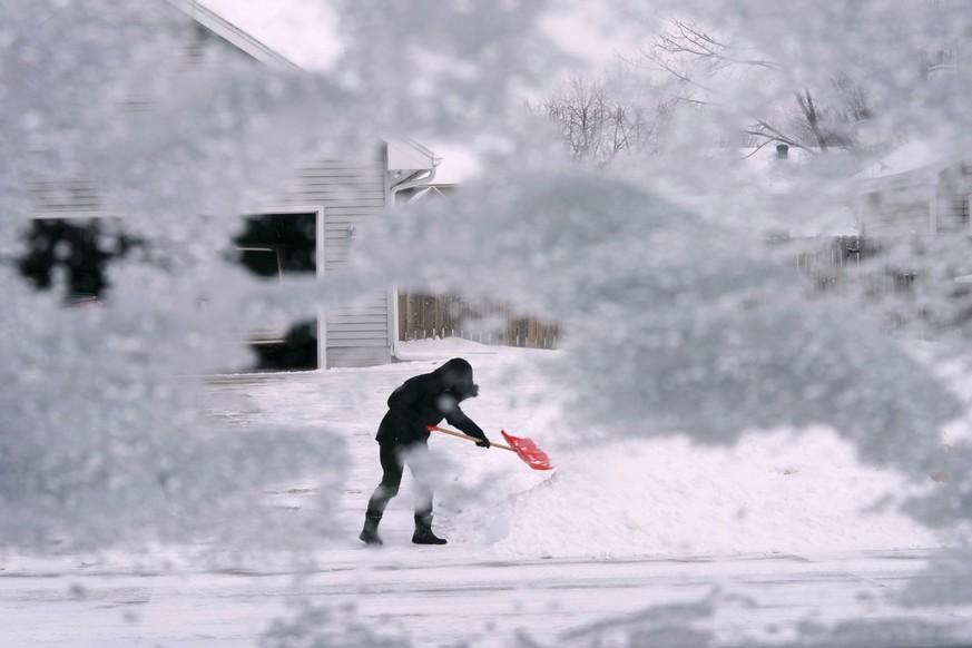 A local resident shovels snow off the end of a driveway, Thursday, Dec. 22, 2022, in Urbandale, Iowa. Temperatures plunged far and fast Thursday as a winter storm formed ahead of Christmas weekend, pr ...