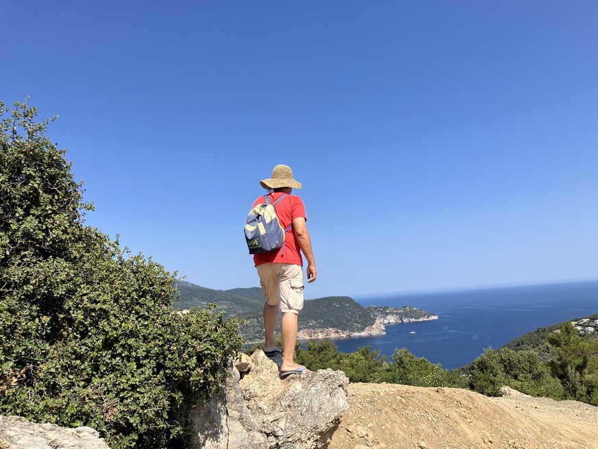 18.06.2024, Griechenland, Skopelos: Ein Tourist geht bei wolkenlosen Himmel auf der griechischen Insel Skopelos wandern. In Griechenland sind seit Anfang Juni 2024 bereits mindestens f