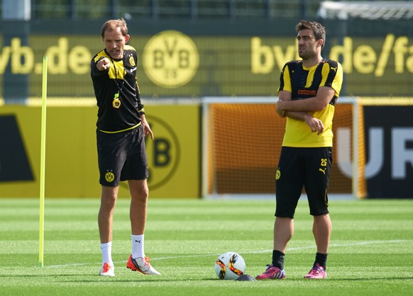 ARCHIV - 25.08.2015, Nordrhein-Westfalen, Dortmund: Borussia Dortmunds Trainer Thomas Tuchel (l) und sein Spieler Sokratis stehen am 26.08.2015 auf dem Trainingsgelände des BVB in Dortmund (Nordrhein- ...