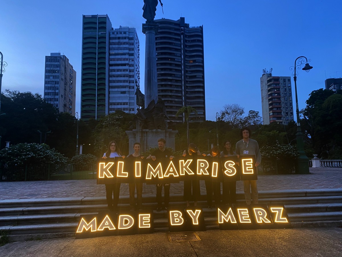 06.11.2025, Brasilien, Belem: Mit einem LED-Schriftzug «Klimakrise made by Merz» stehen Aktivisten von Fridays for Future bei einer Protestaktion in einem Park in Belem. Die Aktion findet in Vorfeld d ...