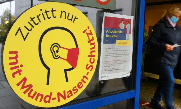 ARCHIV - 15.10.2020, Sachsen, Leipzig: Ein gro�es Schild mit der Aufschrift �Zutritt nur mit Mund-Nasen-Schutz!� weist neben einem Eingang zu einer Klinik in Leipzig auf die Maskenpflicht hin. Weitere ...