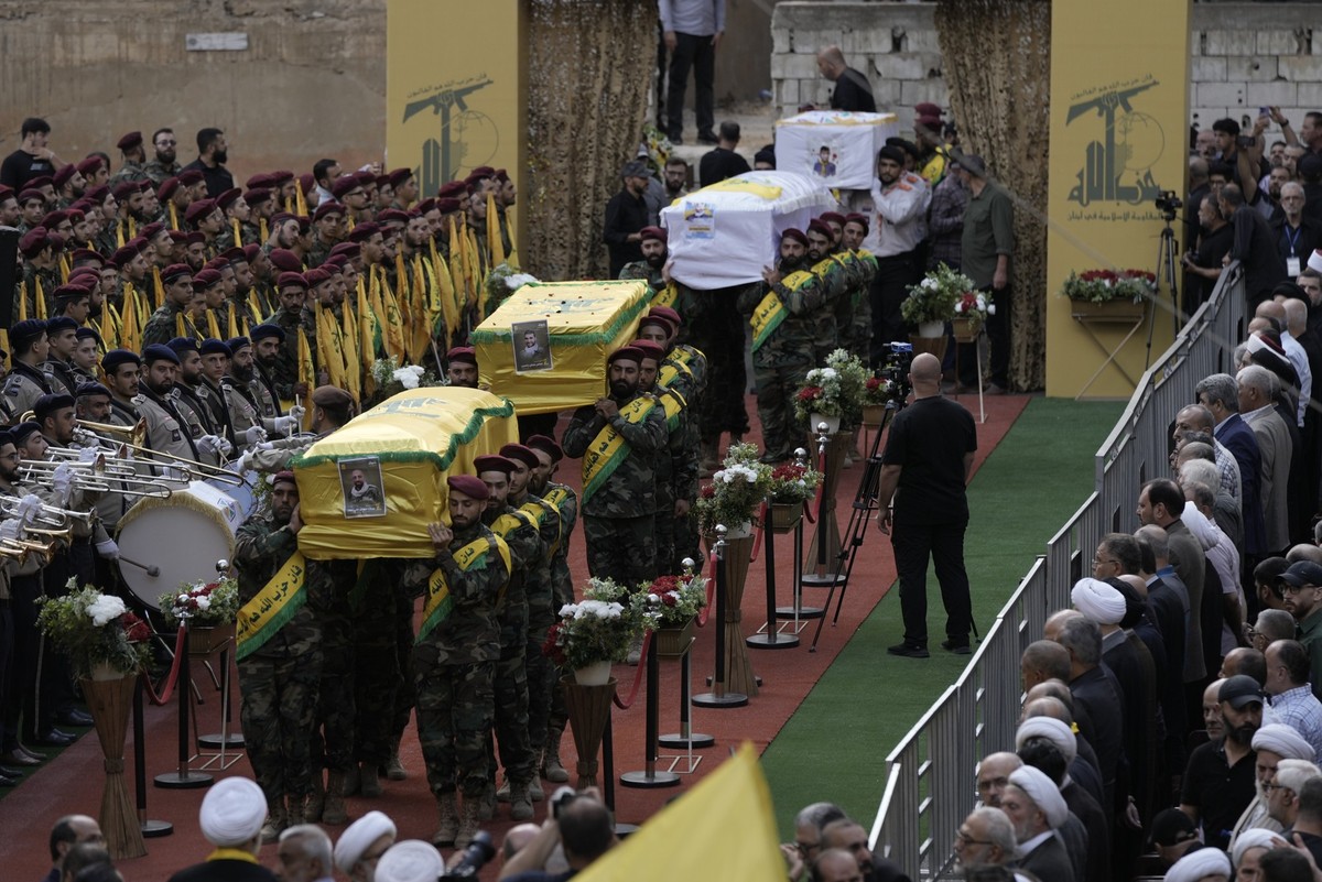 18.09.2024, Libanon, Beirut: Mitglieder der libanesischen Hisbollah-Miliz tragen die Särge von vier gefallenen Kameraden, die am Montag nach der Explosion ihrer tragbaren Pager getötet wurden, während ...