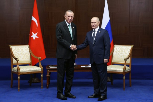 ARCHIV - 13.10.2022, Kasachstan, Astana: Wladimir Putin (r), Pr�sident von Russland, und Recep Tayyip Erdogan, Pr�sident der T�rkei, reichen sich zu Beginn eines bilateralen Treffens am Rande des Gipf ...