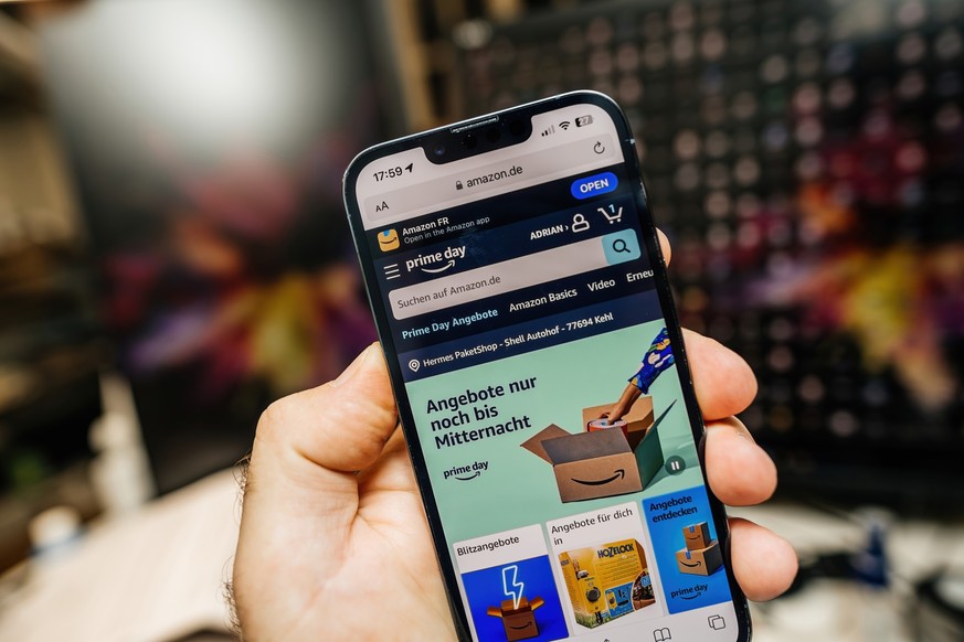 Paris, France - Jul 12, 2023: A male hand holds an Apple iPhone 15 Pro, displaying the German Amazon webpage that invites users to shop during the Prime Day event Model Released Property Released xkwx ...