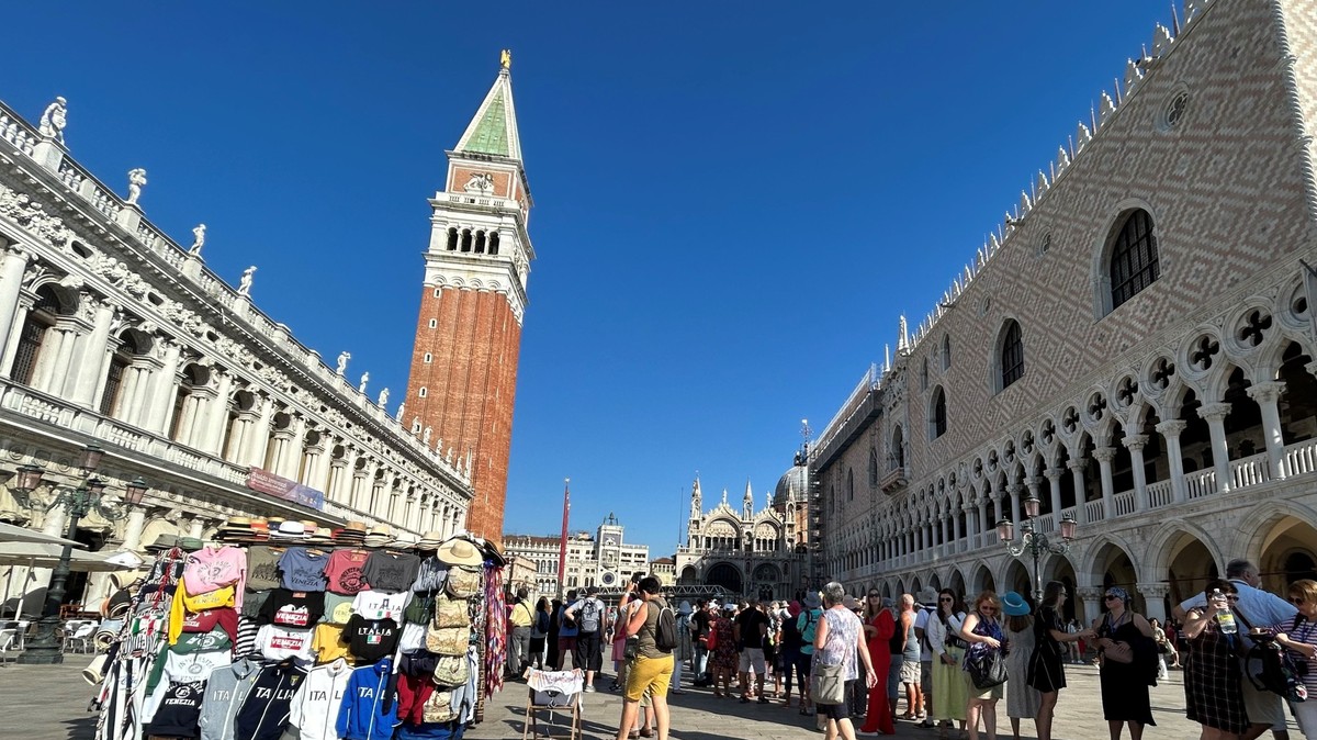 ARCHIV - 11.09.2023, Italien, Venedig: Touristen stehen auf dem Markusplatz mit Campanile (M) und Dogenpalast (r). (zu dpa: