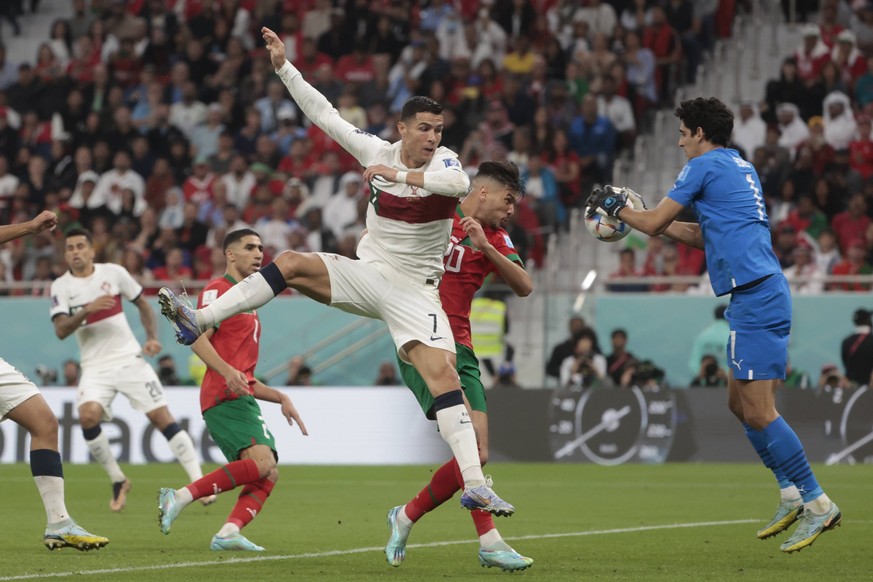 Yassine Bounou R from Morocco disputes a ball with Cristiano Ronaldo from Portugal today, in a match of the quarterfinals of the Soccer World Cup Qatar 2022 between Morocco and Portugal at the Al Zuma ...